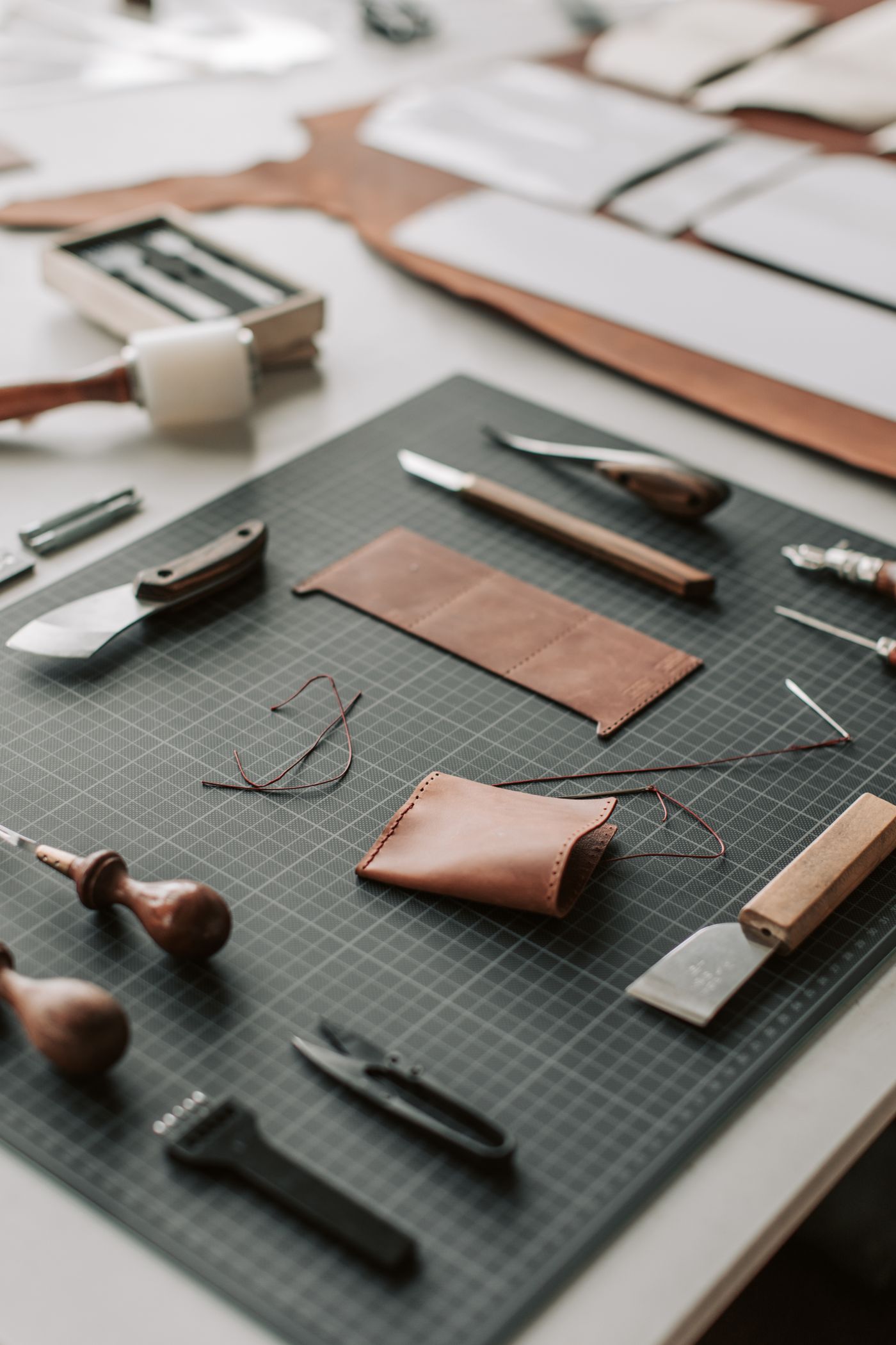 Outils de reliure, cuir brun, fils et réglets disposés sur une table en bois